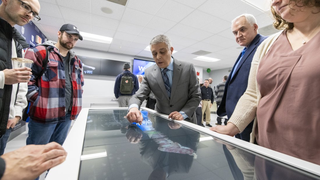 expert demonstrating the Anatomage table technology for a group of viewers